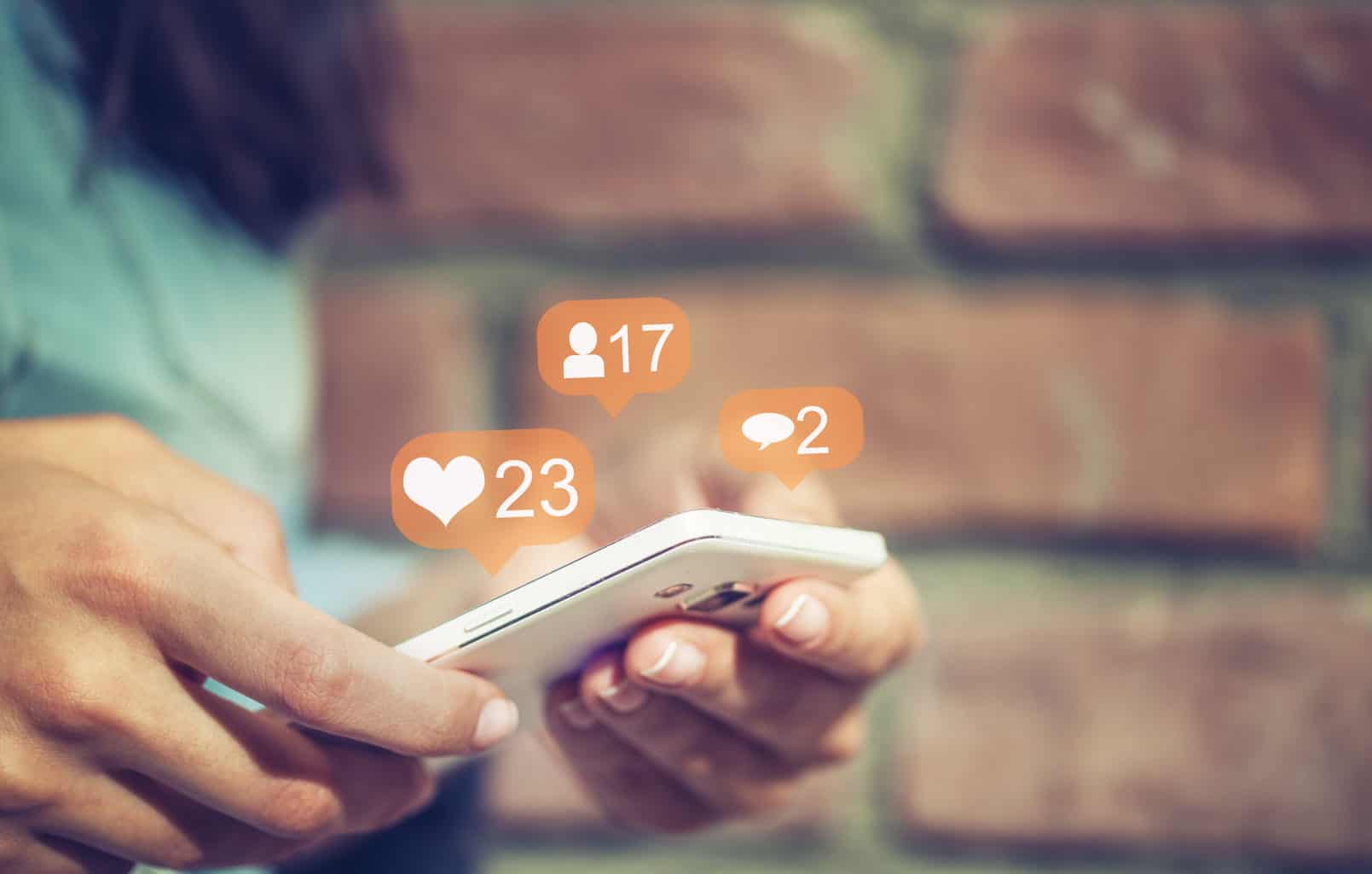 Social Media Policy: A person holds a phone with social media notification symbols above
