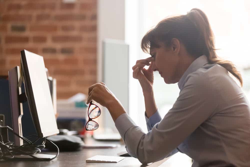 Woman in pain experiencing symptoms of the menopause at work