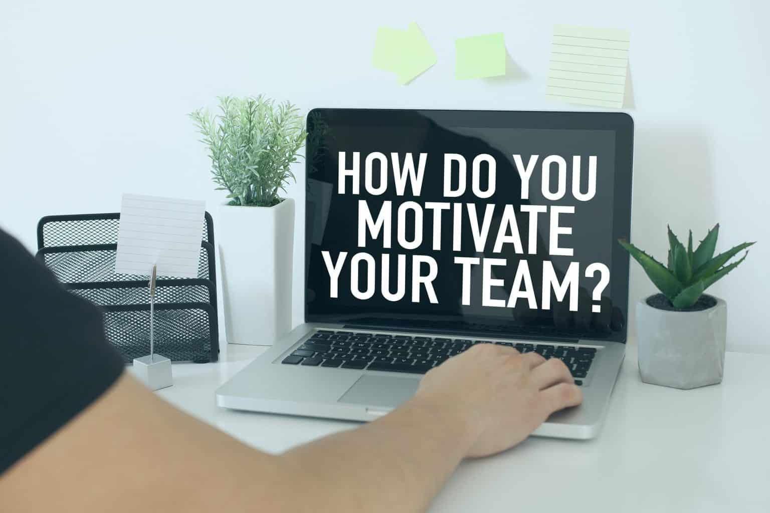 A laptop on a desk reads 'How do you motivate your team?'