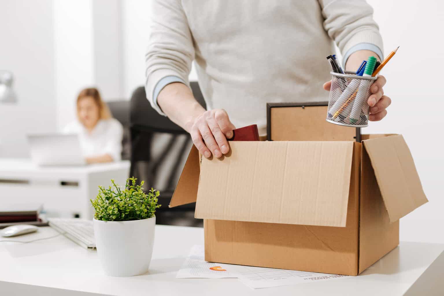 Employee packs belongings into a box following redundancy process