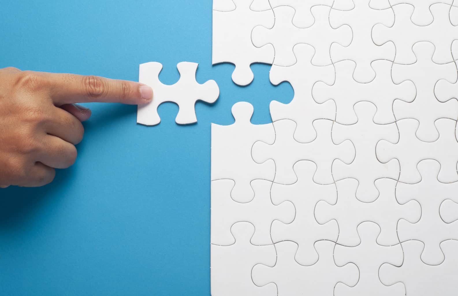 UK points based immigration system after Brexit: A hand pushes a puzzle piece to complete a jigsaw