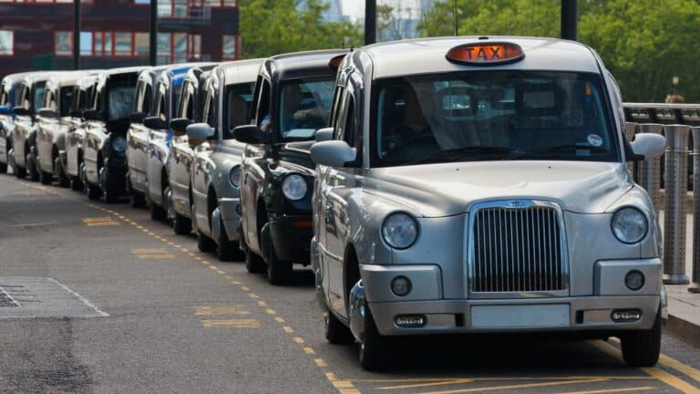 A row of UK Taxis are parked in a Taxi bay - Uber v Aslam