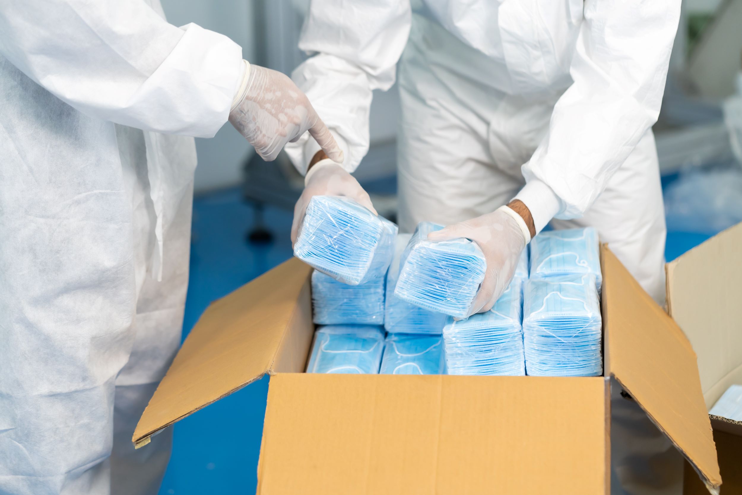 Workers in PPE suits unpack boxes of masks - PPE. Accattatis v Fortuna Group