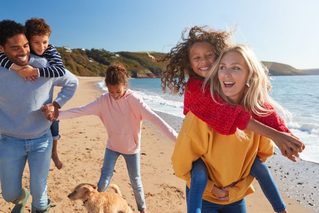 Family Holiday on annual leave. A young family play on the beach during their holiday.