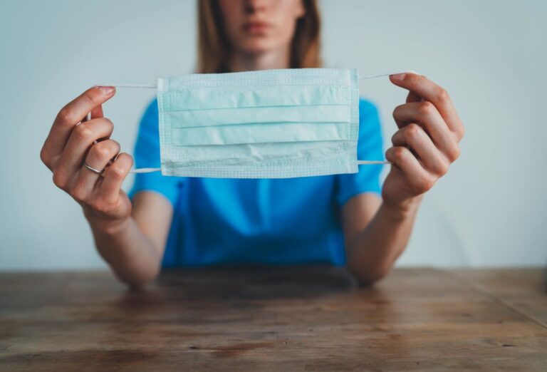 Constructive Dismissal - Care Nursing home worker holds mask in the foreground to protect against coronavirus - Galang v kestrel grove nursing home