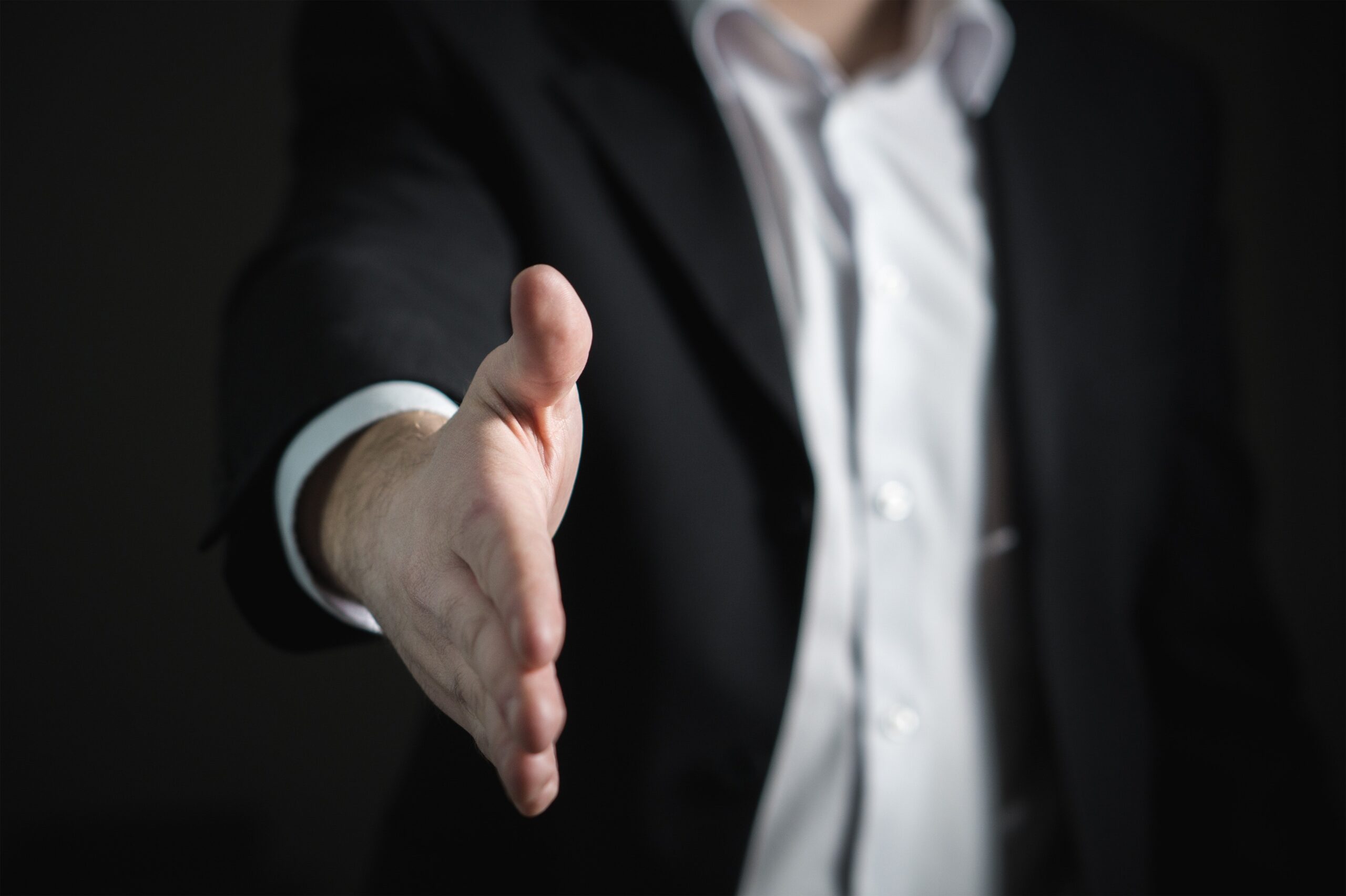 An outreached hand. An employer proposing a settlement agreement in the workplace.