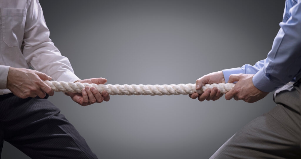 Two employees tugging on opposite ends of a piece of rope. An employment tribunal can feel like a tug of war. 