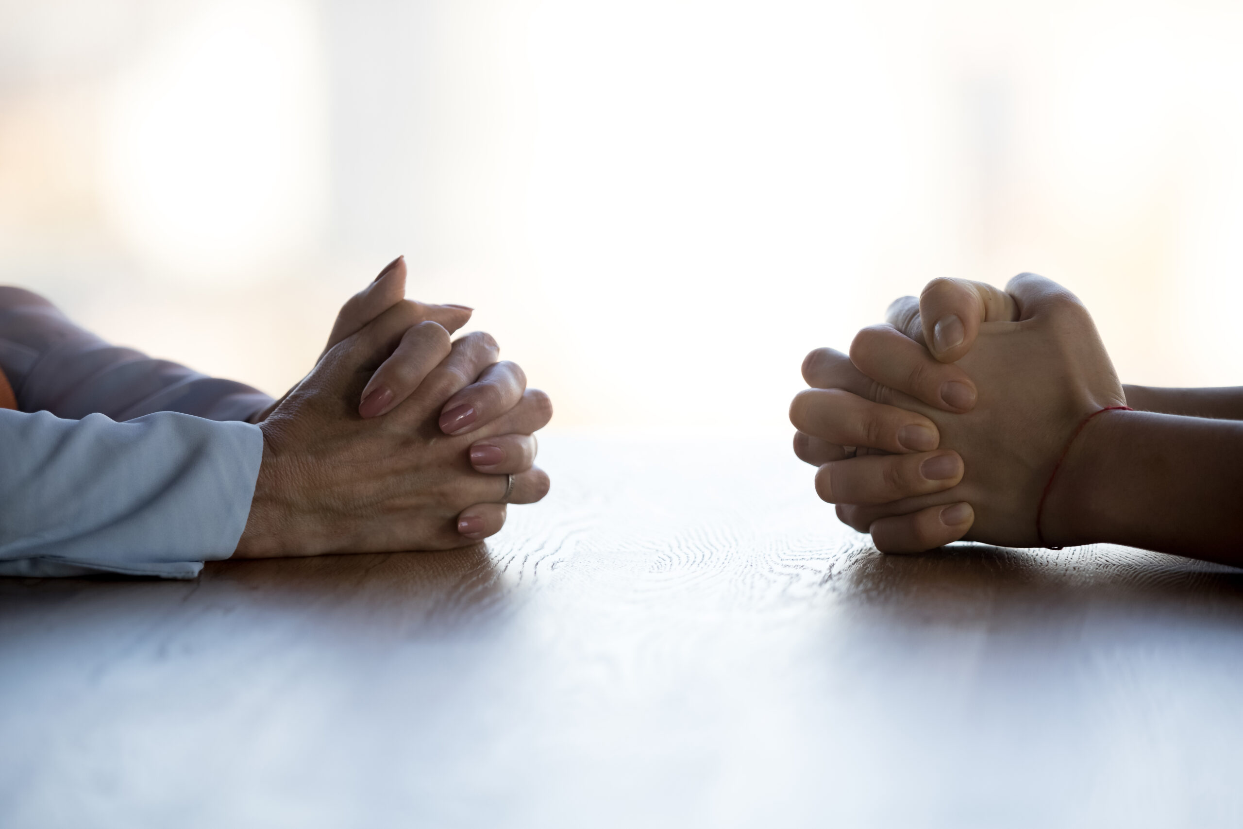 Two people with their hands on a table. An employer's guide to an Employment Tribunal