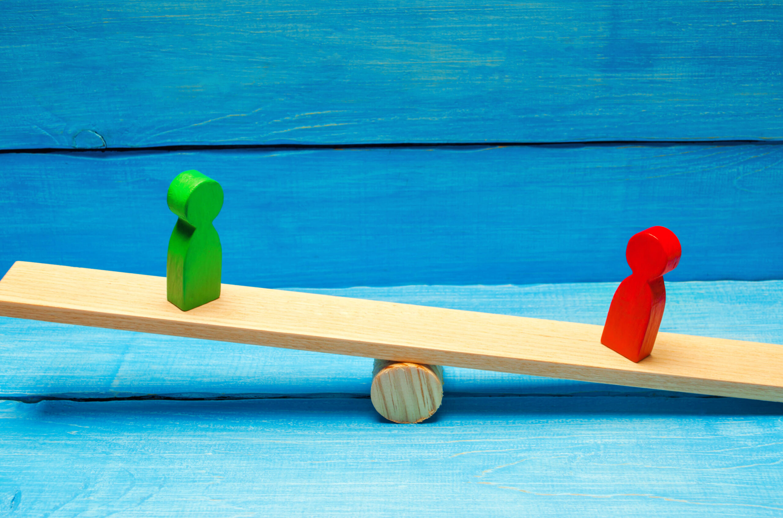 Two wooden figures on a seesaw. Employment tribunal guide for employers. 