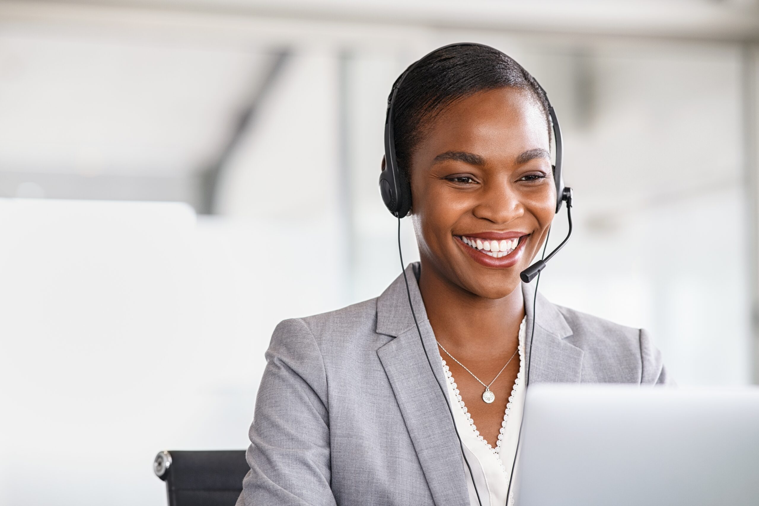 Smiling,African,American,Customer,Care,Representative,Working,With,Headset,In Female smiling with a headset on. Ways to celebrate international women's day 2025.