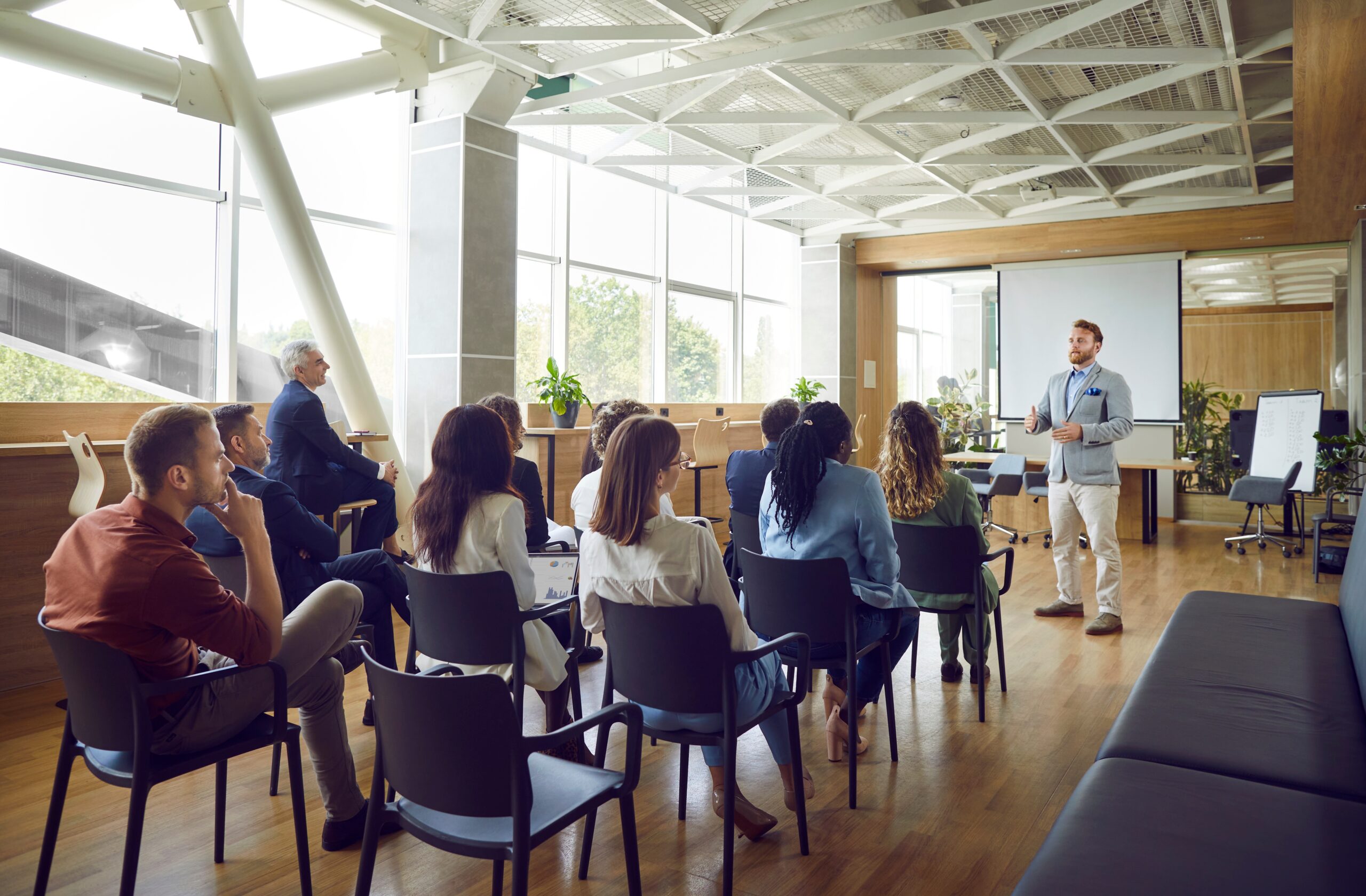 A man standing in front of a group of people at work. Training budgets explained.