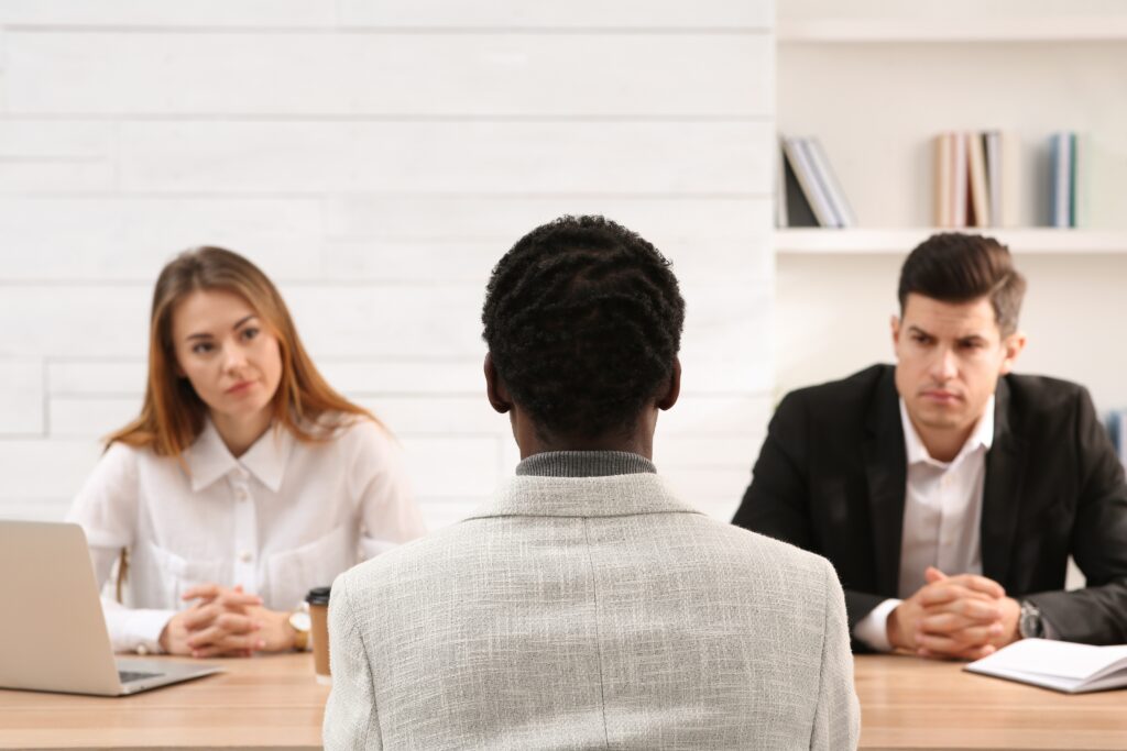 a group of people sitting at a table. Workplace discrimination in the recruitment process.