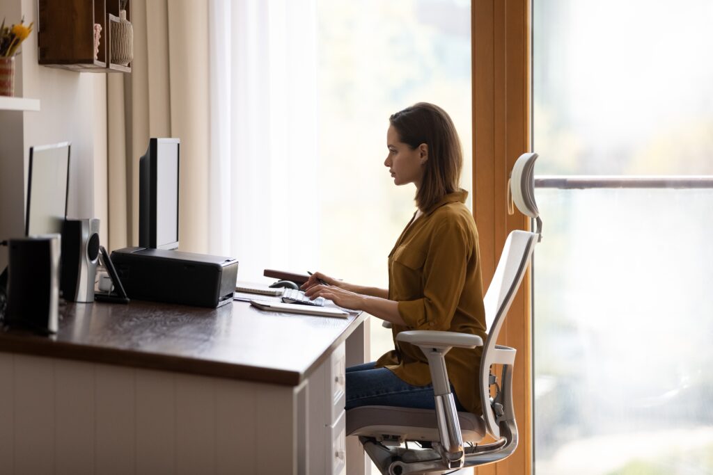 Reasonable adjustments at work. A woman sat in an ergonomic chair with lumbar support.
