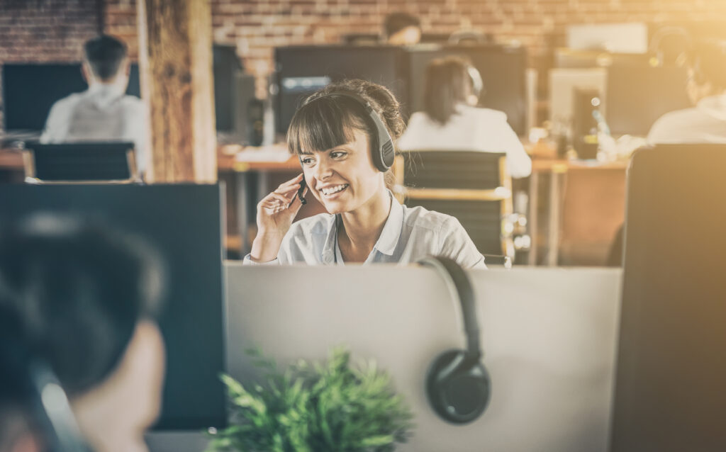 Woman using noise cancelling headset as part of her reasonable adjustments in the workplace.